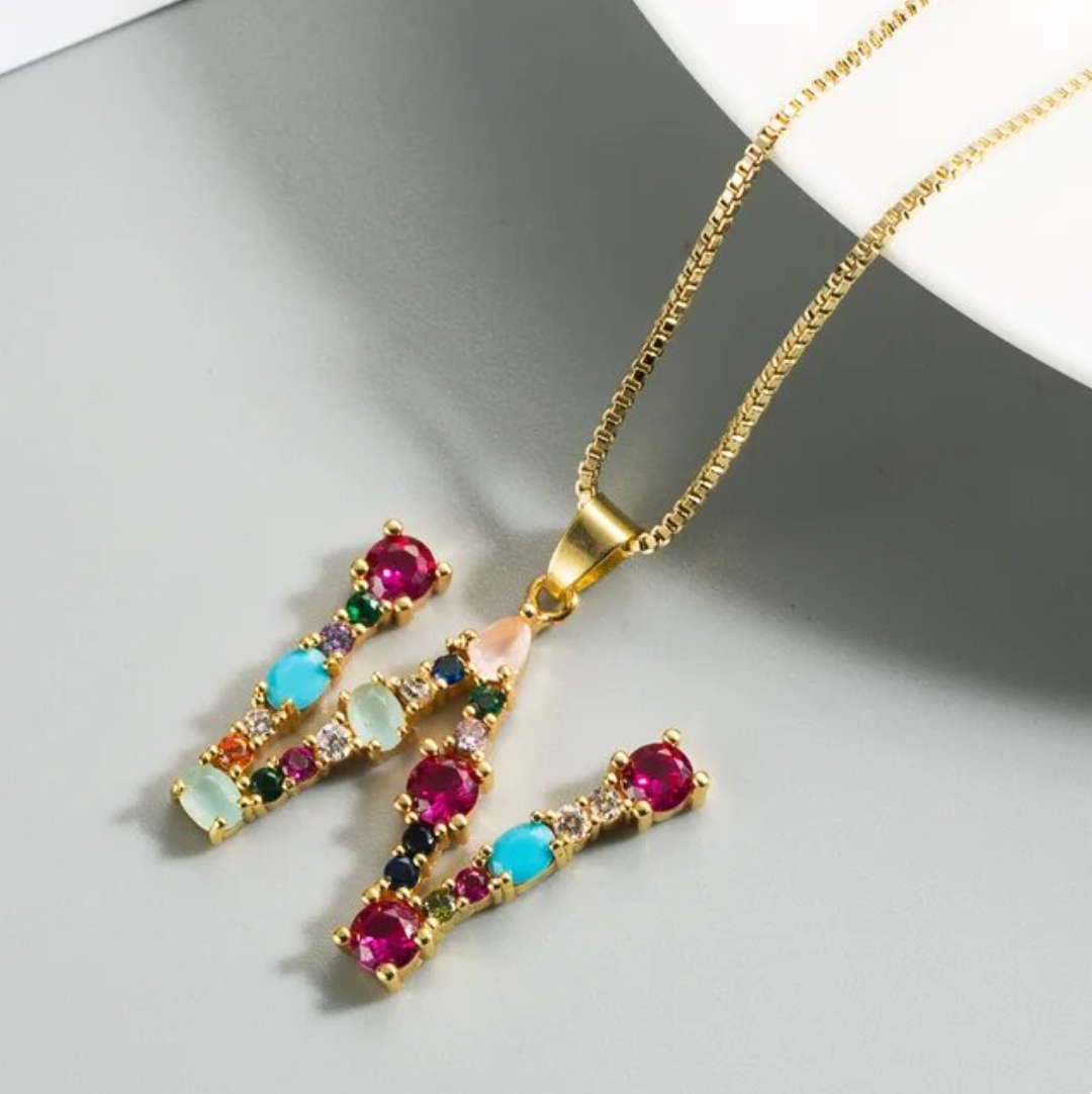 Collar con iniciales y piedras preciosas doradas de 18 quilates