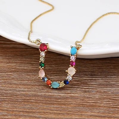 Collar con iniciales y piedras preciosas doradas de 18 quilates