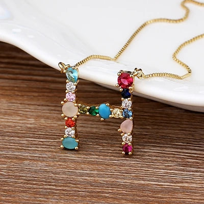 Collar con iniciales y piedras preciosas doradas de 18 quilates