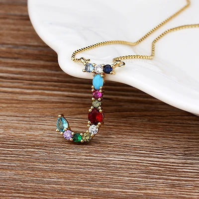 Collar con iniciales y piedras preciosas doradas de 18 quilates