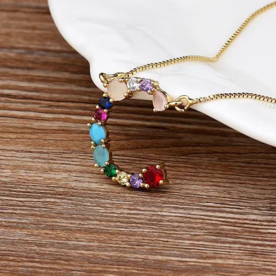 Collar con iniciales y piedras preciosas doradas de 18 quilates